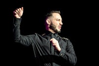 a man in a black shirt with his hands up in the air